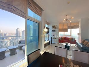 a dining room and living room with a view of the city at Dorra Bay Tower Dubai Marina - AL Maraseem in Dubai