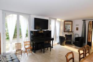 un soggiorno con pianoforte e TV di "Villa "Les Oliviers" garden air conditioning city center" a Antibes