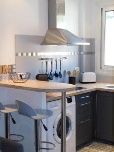 a kitchen with a washing machine under a counter at T1 "Santa Luccia" with air conditioning in Saint-Laurent-du-Var