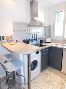 a kitchen with a washing machine and a sink at T1 "Santa Luccia" with air conditioning in Saint-Laurent-du-Var