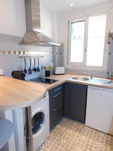 a kitchen with a washing machine and a sink at T1 "Santa Luccia" with air conditioning in Saint-Laurent-du-Var