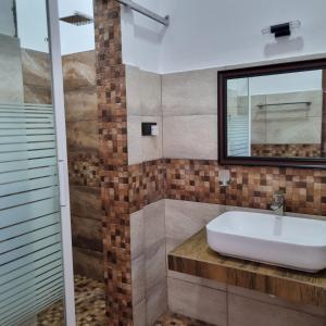 a bathroom with a sink and a mirror at Dhammika Beach Palace in Wadduwa