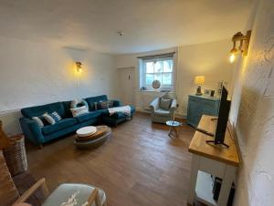 salon z niebieską kanapą i stołem w obiekcie Pinnacle Cottage grade II listed home at the coast w mieście Heacham