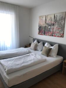 two beds in a bedroom with a painting on the wall at Ferienwohnung Talbach in Schladming