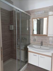 a bathroom with a glass shower and a sink at Palaiokastro view in Karpathos Town