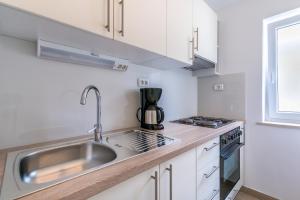 a kitchen with a sink and a stove at Barbic in Medulin