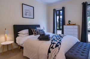 1 dormitorio con 1 cama y 1 silla azul en Alfies on Albert Daylesford, en Daylesford