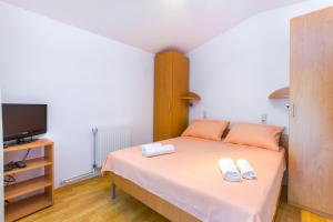 a small bedroom with a bed and a tv at Barbic in Medulin
