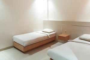 a bedroom with two beds and a window at TwoSpaces Living at KR Hotel in Palembang