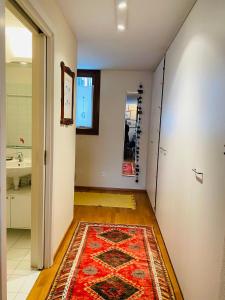 a hallway with a rug on the floor and a bathroom at A casa di Gio' in Bosco Gurin