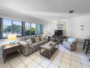 a living room with a couch and a tv at Hidden Beach Villas - 111 Villa in Santa Rosa Beach