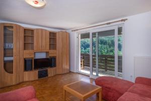 a living room with a red couch and a large window at Iglica Apartments - First Floor in Bohinjska Bela