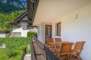 a patio with a table and chairs on a balcony at Iglica Apartments - First Floor in Bohinjska Bela +9 photos