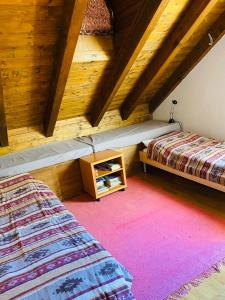 1 dormitorio con 2 camas y techo de madera en A casa di Gio', en Bosco-Gurin
