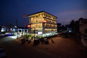ein Gebäude mit Motorrädern, die nachts davor geparkt sind in der Unterkunft RG's The 4th Residency in Thiruvananthapuram