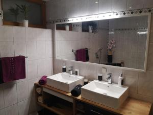 La salle de bains est pourvue de 2 lavabos blancs et d'un miroir. dans l'établissement Tiroler Wohnung, à Arzl im Pitztal