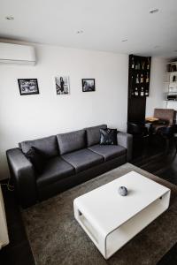 salon z czarną kanapą i białym stolikiem kawowym w obiekcie AH Kuzmányho w Koszycach