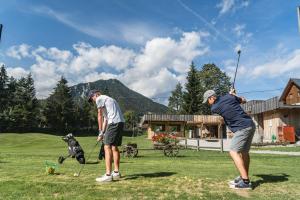 two men playing a game of golf with a dog at Sport & Sunny Cosy Alpine Retreat in Kranjska Gora