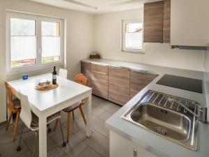 cocina con fregadero y mesa con encimera en Chalet Soldanella, en Grächen