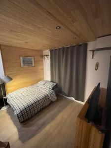 - une chambre avec un lit dans une pièce dotée de plafonds en bois dans l'établissement Appartement Les Orres au pied des pistes !, aux Orres