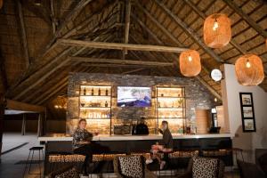 a group of people sitting at a bar at Mongena Private Game Lodge in Rust de Winter