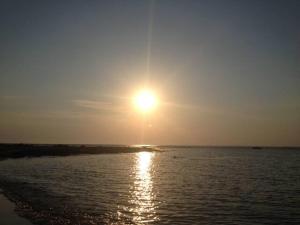 Sonnenuntergang über dem Wasser am Strand in der Unterkunft Appartamento Perla Del Salento Porto Cesareo in Porto Cesareo