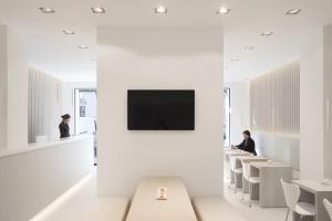 a waiting room with white tables and a tv on the wall at Hotel Aurora in Pavia