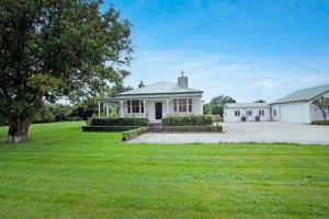 a large white house with a grass yard at Botham's Beauty - Blenheim Holiday Home in Blenheim