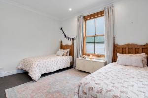 a bedroom with two beds and a window at Botham's Beauty - Blenheim Holiday Home in Blenheim