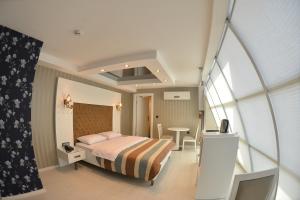 a small bedroom with a bed and a table at R S CİTY HoTEL in Samsun