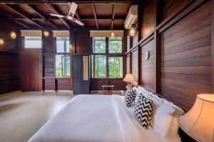 a bedroom with a large bed in a room with wooden walls at SaffronStays Boulevard LogHouse - a wooden chalet amidst nature in Kārli