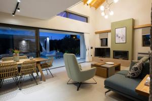 uma sala de estar com um sofá, uma mesa e cadeiras em Olive green villas em Lefkada