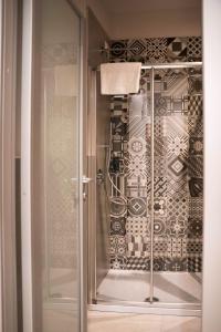 a glass shower door in a room with a wall at Terranova49 in Novara