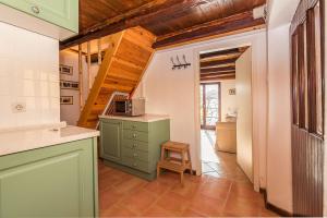 une cuisine avec un meuble vert et un escalier dans l'établissement Little Vista, à Kojsko