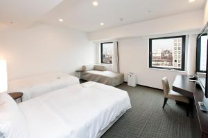 Postel nebo postele na pokoji v ubytování Sotetsu Fresa Inn Yokohama Sakuragi-cho