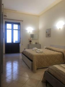 een grote kamer met 2 bedden en een raam bij Monolocale in Via Poerio in Catanzaro