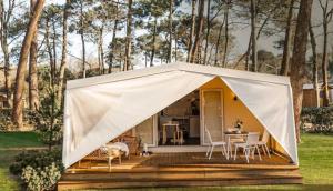 a tent with a table and chairs on a deck at Camping Serenissima in Malcontenta