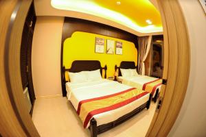 2 Betten in einem kleinen Zimmer mit Spiegel in der Unterkunft LAHONA HOTEL in La Gi