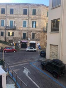 een parkeerplaats met auto's voor een gebouw bij Monolocale in Via Poerio in Catanzaro