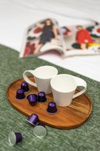 a wooden tray with cups and saucers next to a book at Lively new apt with Bomb Shelter beside the beach M5 in Tel Aviv
