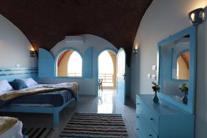 Schlafzimmer mit blauen Wänden und Bogenfenstern in der Unterkunft Noprea Boutique Hotel in Assuan