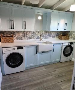 a kitchen with white cabinets and a sink and washing machines at Villa Kayi Kottage in Peaceful calis few minutes from Çaliş sunny Beach in Fethiye