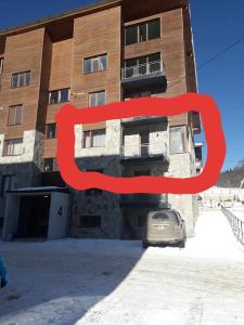 un bâtiment avec un panneau rouge devant lui dans l'établissement Khatuna’s apartment in villa monte, à Bakuriani
