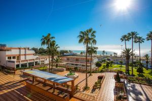Hotel Club Almoggar Garden Beach في أغادير: اطلالة على منتجع فيه مسبح والنخيل