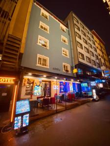 イスタンブールにあるAdora Hotel Cafe & Restaurantの夜間の通りにテーブルと椅子が並ぶ建物