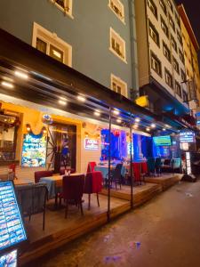 a restaurant with tables and chairs on a street at night at Adora Hotel Cafe & Restaurant in Istanbul