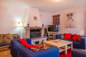 a living room with blue couches and a fireplace at Mala Vas Chalet in Bovec