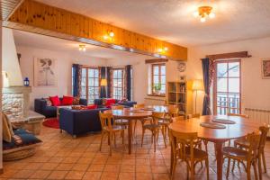 a living room with tables and chairs and a couch at Mala Vas Chalet in Bovec