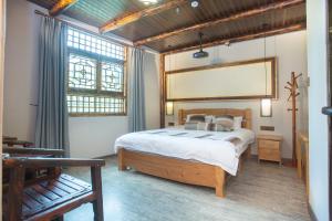 a bedroom with a bed and a large window at Nanjing Tulou Xinyuan HomeStay in Nanjing