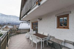 a patio with a table and chairs on a balcony at Mala Vas Chalet in Bovec